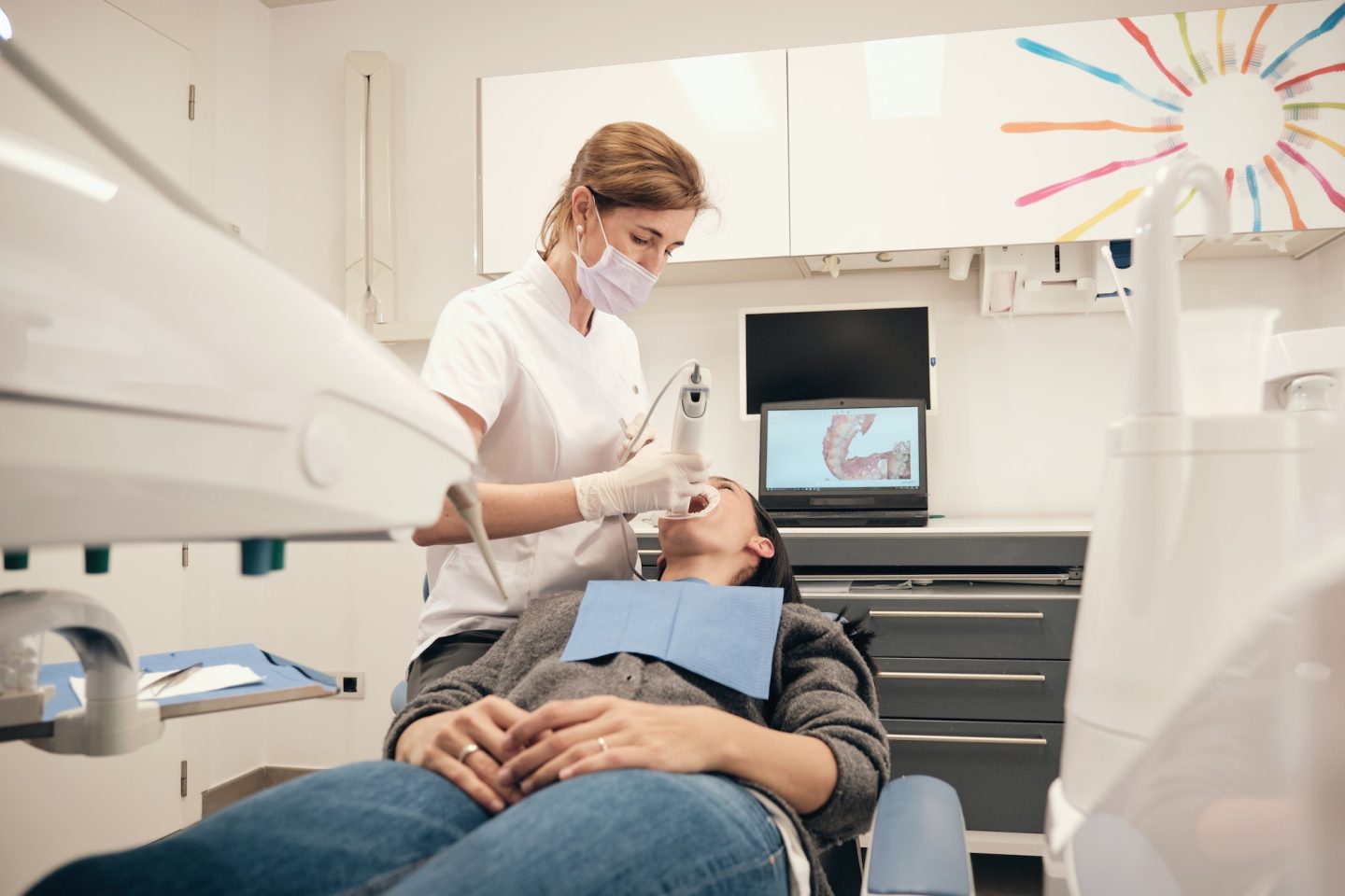 Female dentist scanning teeth of woman
