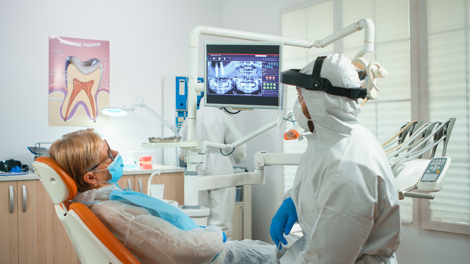 Orthodontist in special equipment pointing on digital x-ray