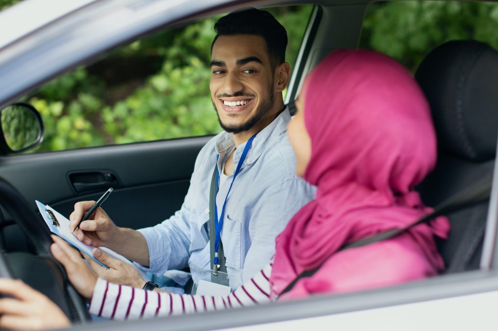 Driving School Test. Handsome Young Arab Instructor Examining Muslim Female Drive