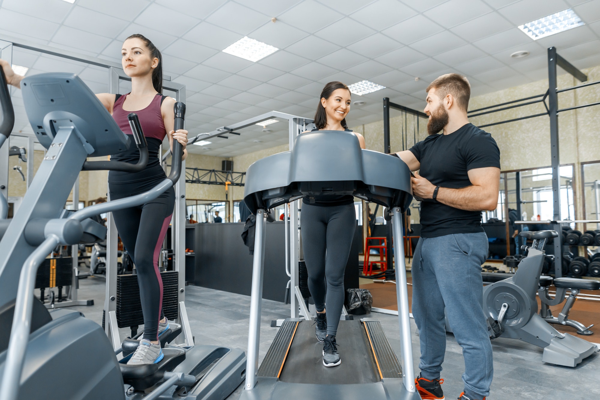 Young smiling fitness women with personal trainer