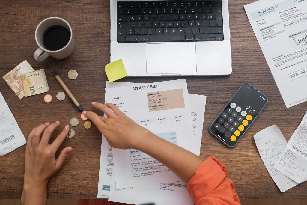 woman manages family finances, calculating expenses and counting money and coins to pay bills