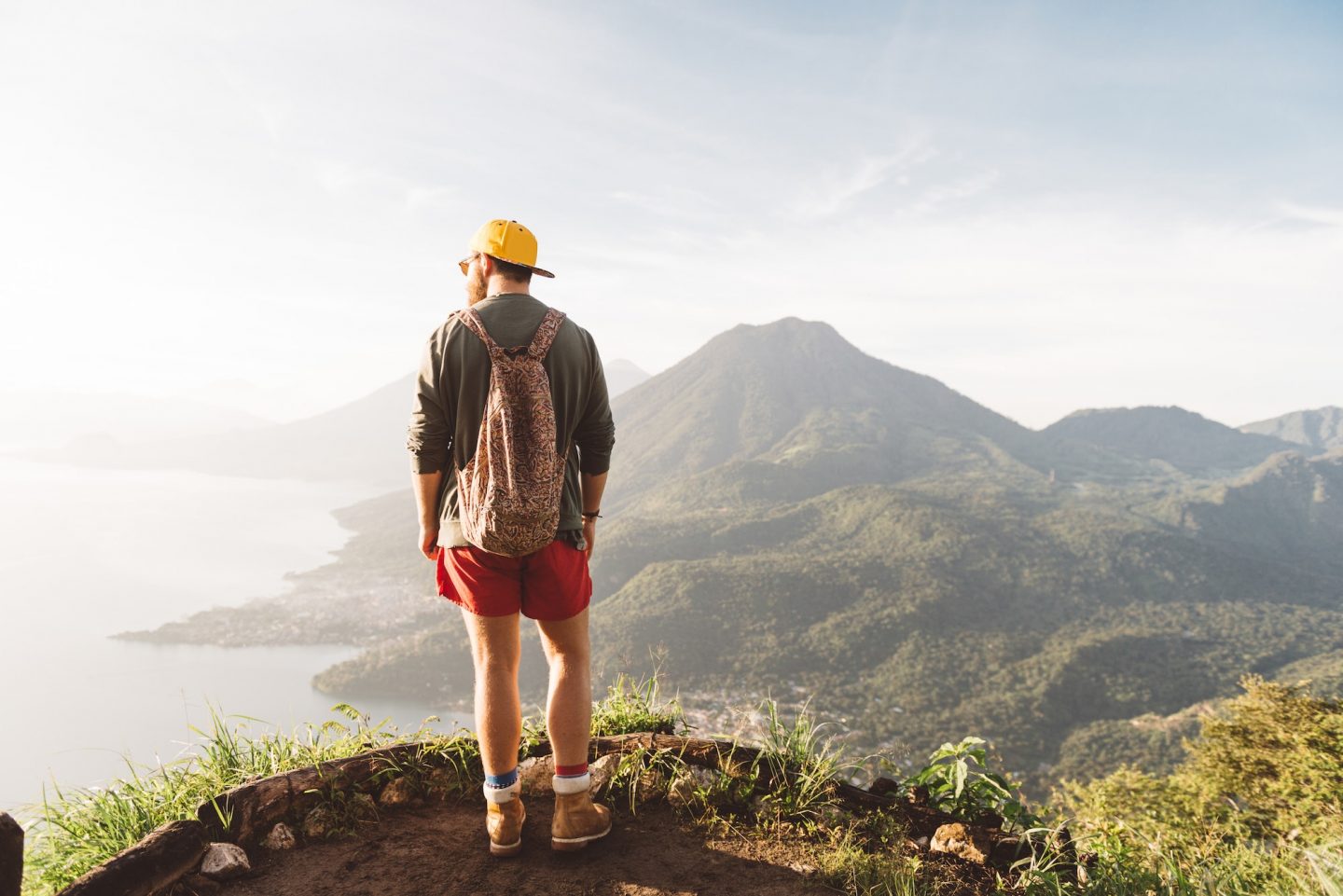 Rear view of young man looking out over Lake Atitlan, Guatemala