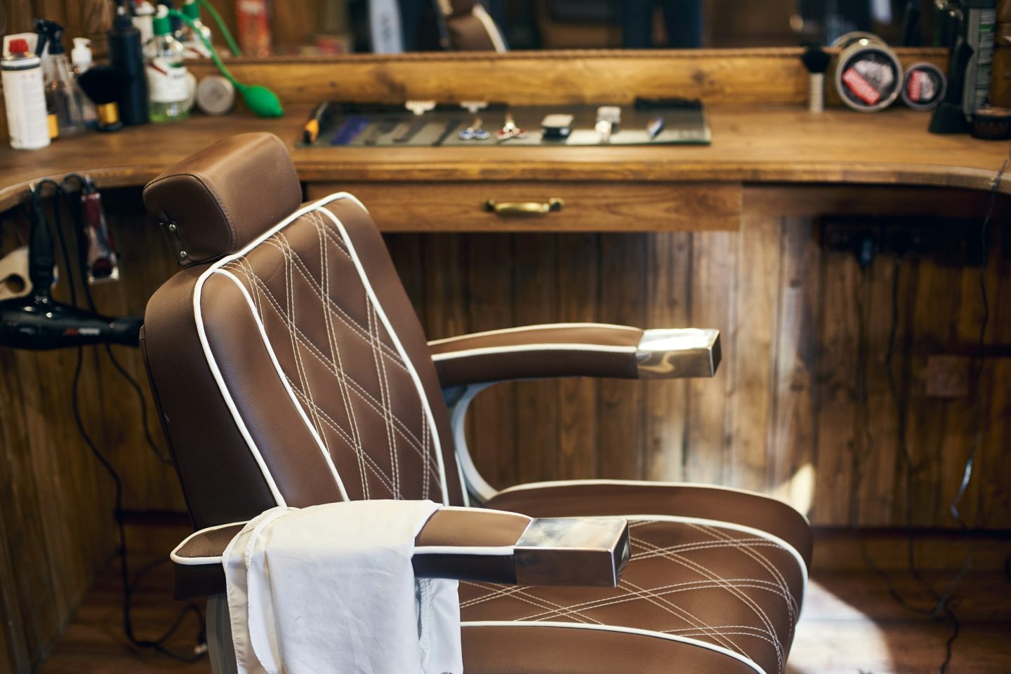 Empty barber chair in wooden interior. Vintage workplace in studio for haircuts.